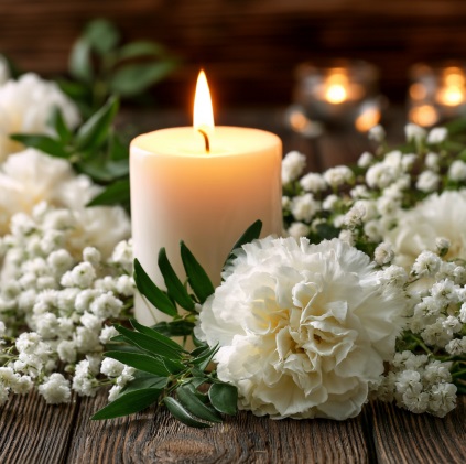 Memorial candle and white flowers representing cremation services in Mooreland, IN.