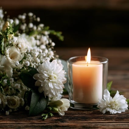 Memorial candle and white flowers representing funeral homes in Mooreland, IN.